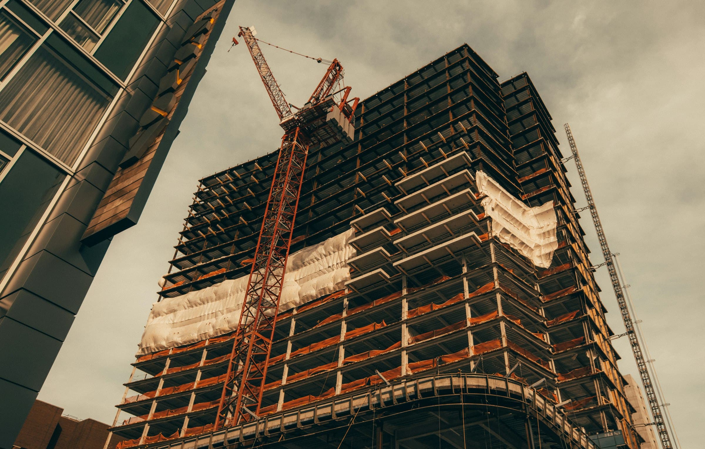 High-rise under construction with a tower crane at its side