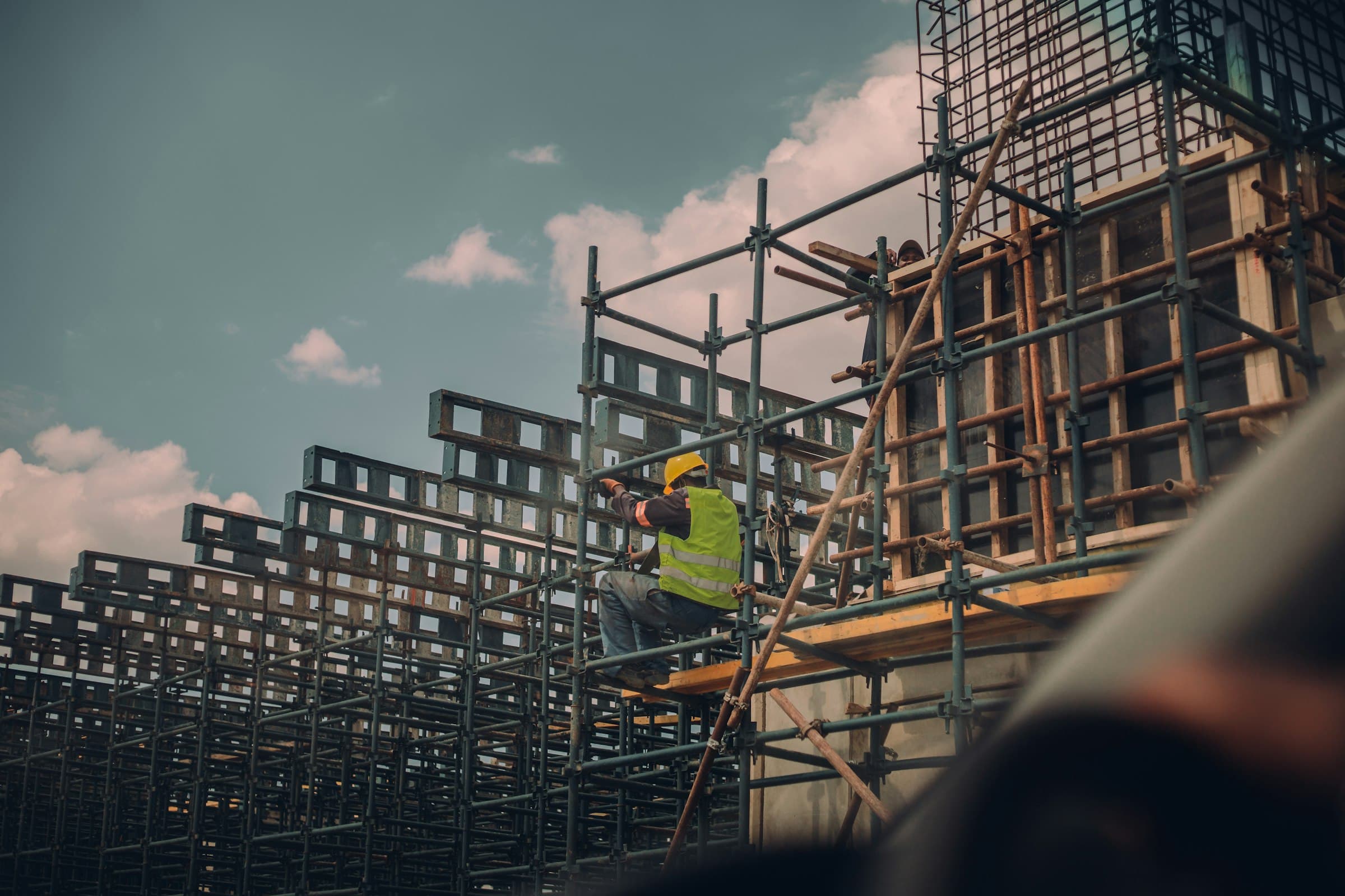 Worker on scaffolding around a structure under construction