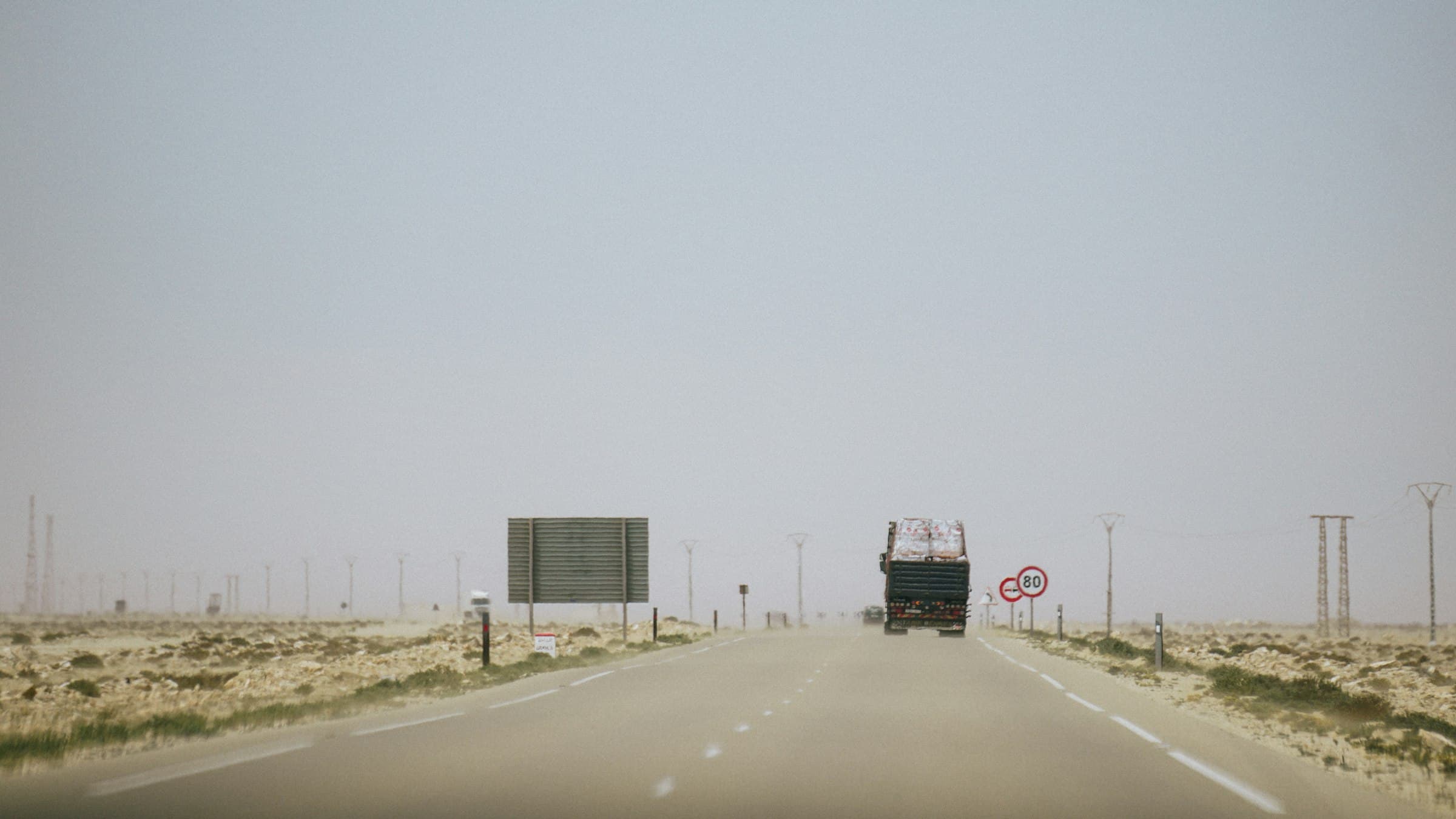 Freight truck on a desert highway in haze